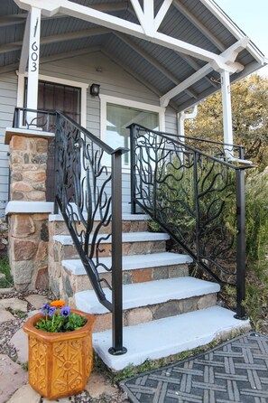 Local ironworks artist created porch and step railing.