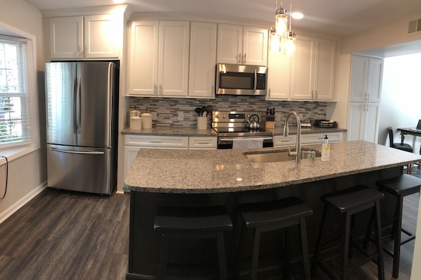 New renovated kitchen with granite countertops, new appliances & tile backsplash