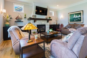 living room has 3 motorized reclining easy chairs around the fireplace.