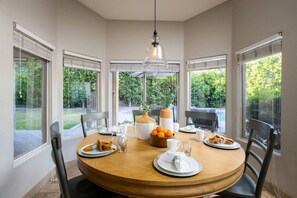 Dine with a view: Our charming dining area is surrounded by windows, offering a stunning outdoor panorama