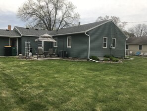 Enjoy the patio in the peaceful backyard with a table, six chairs, and grill.