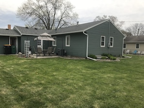 Enjoy the patio in the peaceful backyard with a table, six chairs, and grill.