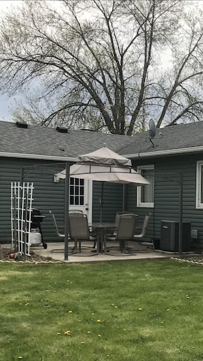 Enjoy the patio in the peaceful backyard with a table, six chairs, and grill.