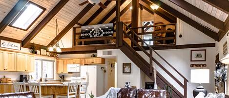 This photo captures the living room, kitchen and the view going up to the loft.