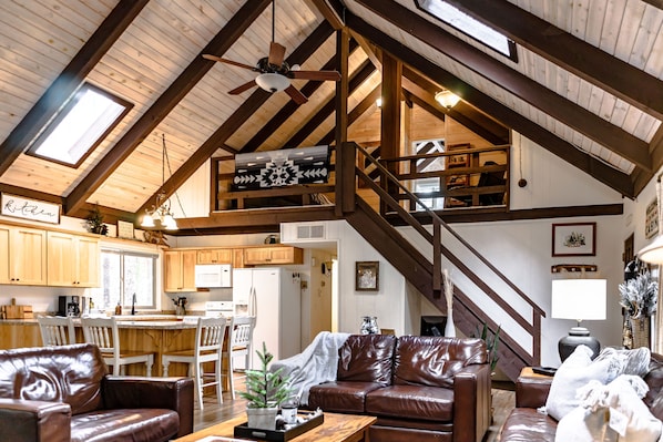 This photo captures the living room, kitchen and the view going up to the loft.