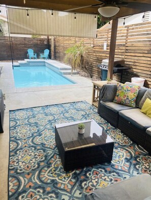 Backyard with pool, fence, and large couch to relax