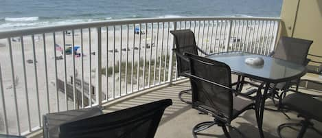 Large balcony with table and four chairs plus (2) lounge chairs.