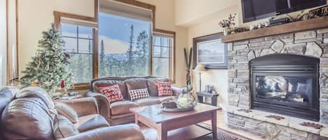 Living Area - High ceiling, fireplace, and flat screen TV.