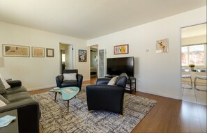 Large, bright living room with leather sleeper sofa.   