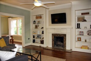 Original built-ins in living room with gas fireplace and smart TV with Netflix