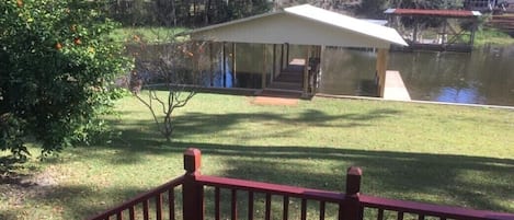 Lakeside front yard deck, orange trees, and boat house with 2 fishing piers