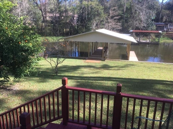 Lakeside front yard deck, orange trees, and boat house with 2 fishing piers