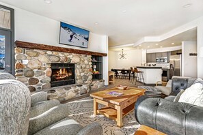 Warm living area with wood burning fireplace, flat screen TV and access to the deck.