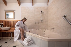 The double hydrotherapy massage spa with bathrobes towels toiletries and candles