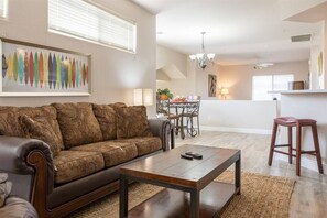 Living room and eat-in kitchen with high counter top and seating