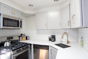 The kitchen is fully stoked with every utensil and appliance one would need to make a home cooked meal.