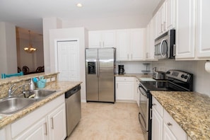 There Are Stainless Steel Appliances With An Open Concept Kitchen