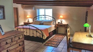 Large bedroom with sitting area and desk. King-size bed.