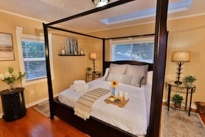 Master bedroom featuring a king bed, two mirrored closets, and a skylight.