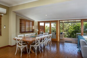 Large dining area with bifold doors that open onto the pool area 