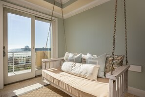 spacious living room with swings overlooking private balcony with beachfront views