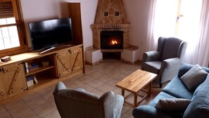 Detalle del salón comedor con la chimenea y la TV curva Samsung ultraHD de 49".