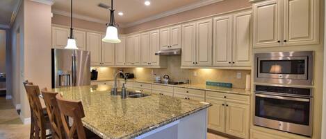The Kitchen of The Home Has Stainless Steel Appliances and Granite Counter Tops