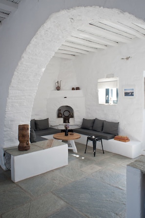 The living room from the kitchen, the stone arch and its traditional fireplace