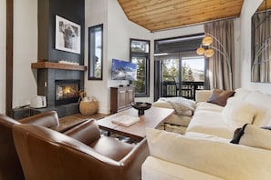 Inviting Living Room with Beautiful Pine Soaring Ceilings, Wood Burning Fireplace and TV.