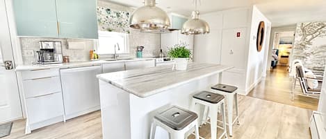 Beautiful new kitchen with marble counters, center island with seating.
