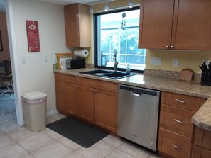 A fully equipped Kitchen, overlooking both the Dining Room and the Pool Deck.