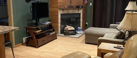 Living room with real woodburning fireplace, 42” flat screen TV, and DVD player.