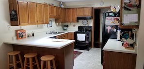 Kitchen area w/bar seating.  Fridge, stove, microwave, coffee maker, & toaster.