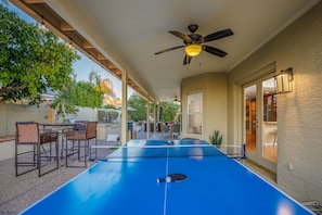 Huge covered patio with outdoor games and a ping-pong table.