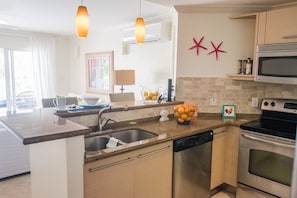 Kitchen looks out to the Living Area and Patio