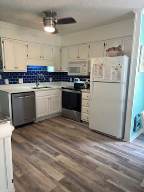 Updated kitchen with new floors, stove, dishwasher and quartz countertops