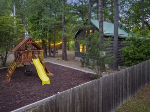 Sitting between the drive and the cabin is a playset for the kiddos!