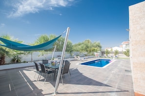 Shaded dining area with table and chairs to seat 6 people