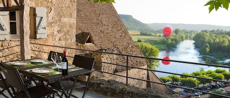 Dinner on the terrace shadowed  by platan  tree with view over the Dordogne