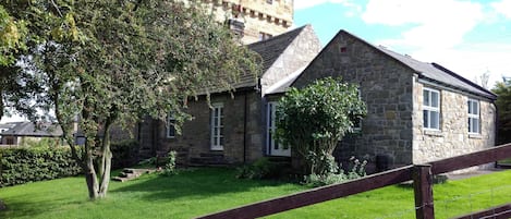 The cottage sits against the 13C Pele tower