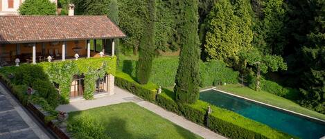 View of the pool, outdoor dining portico, garden and terrace from bedroom 1