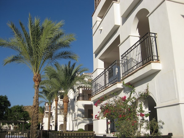 View of apartment balcony from poolside