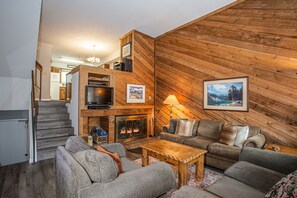 Cozy living room with wood burning fireplace and sofa sleeper