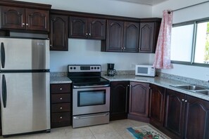 Kitchen with full refrigerator, etc.