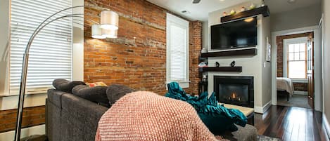 Living room with pull out couch, fireplace and tv.