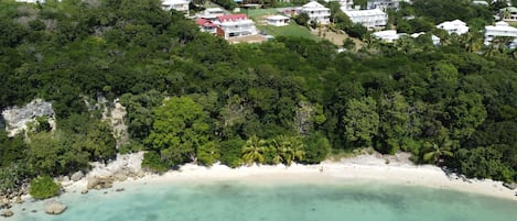 Le bungalow au toit rouge et la plage au-dessous
