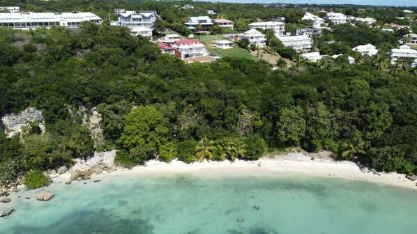 Le bungalow au toit rouge et la plage au-dessous
