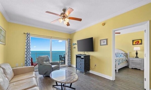 Living room with awesome view, leather queen sleeper sofa with memory foam mattress, 2 leather rocker/swivel recliners, 55" SMART TV & balcony access