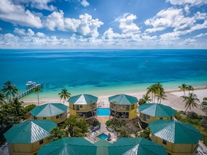 Aerial view looking out on the pool and beachfront on a typical tropical day.