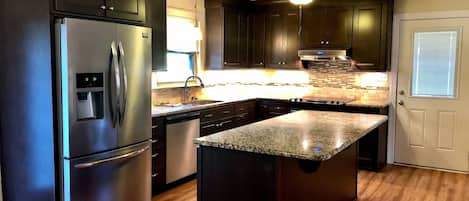 Roomy kitchen with pots, pans, silverware and other cooking utensils 